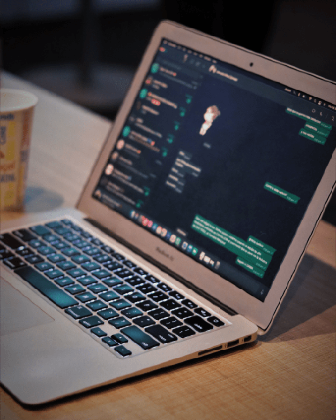 Notebook sobre uma mesa com uma conversa de WhatsApp aberta na tela